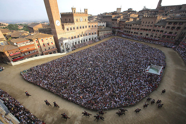 Horses and jockeys compete in a general practice of the Palio horse race on the eve of the competition on July 1, 2009 on Piazza del Campo in Siena, Tuscany. The Palio races which take place twice a year on July 2 and August 16, are  traditional horse races which started in 1656 and are dedicated to Virgin Mary and to Madonna of Provenzano. Horses and jockeys of the 17 areas (contrade) of the city, dressed in the appropriate colors of their wards, compete ten by ten, after a magnificient pageant, the Corteo Storico.  AFP PHOTO / Fabio Muzzi (Photo credit should read FABIO MUZZI/AFP/Getty Images)